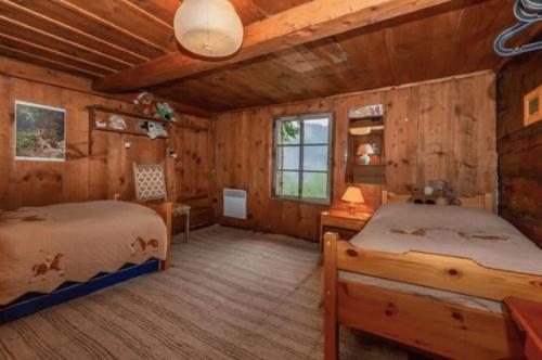 a bedroom with two beds in a cabin at Heidi Chalet in Rossinière