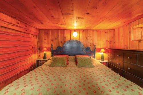 a bedroom with a bed in a room with wooden walls at Heidi Chalet in Rossinière