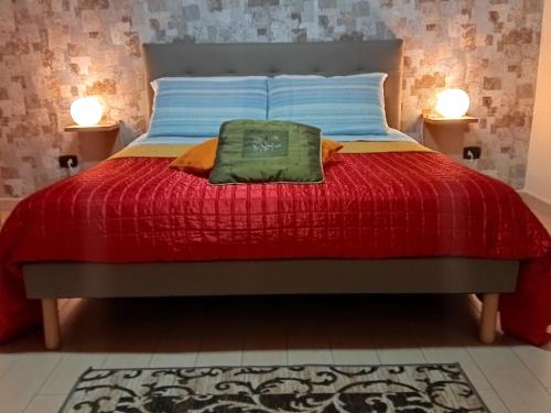 - un lit avec une couette rouge et 2 lampes dans l'établissement Casa-B&B Bouganville Attico 85 mq, à Barletta