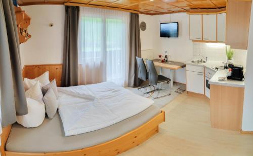 sypialnia z dużym łóżkiem i kuchnią w obiekcie Ferienhaus Mühlstein w mieście Silbertal