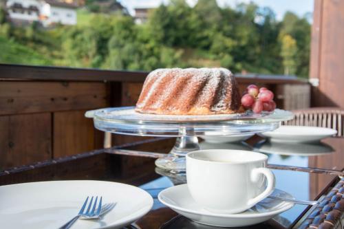 a table with a cake and a cup of coffee at Ferienhaus Mühlstein in Silbertal
