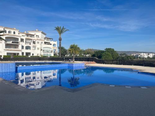 ein großes Schwimmbad vor einem Gebäude in der Unterkunft La Casa Rosita, Hacienda Riquelme Golf Resort Sucina in Murcia