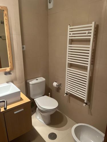 a bathroom with a white toilet and a sink at La Casa Rosita, Hacienda Riquelme Golf Resort Sucina in Murcia