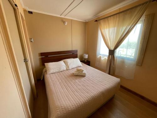 a small bedroom with a bed with a window at Cabañas Pankara in San Pedro de Atacama