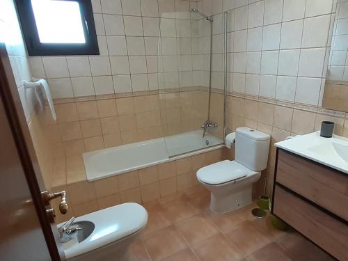 y baño con aseo, bañera y lavamanos. en Villa Elisa en Villaverde