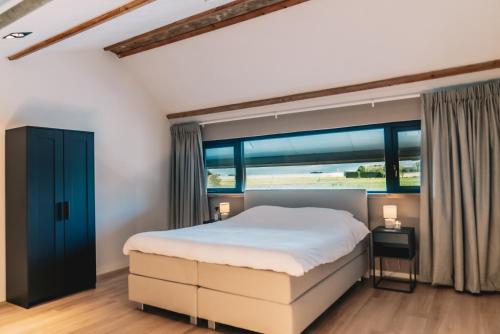 a bedroom with a bed and a large window at Wellness Bed & Breakfast by Leef in Maasland