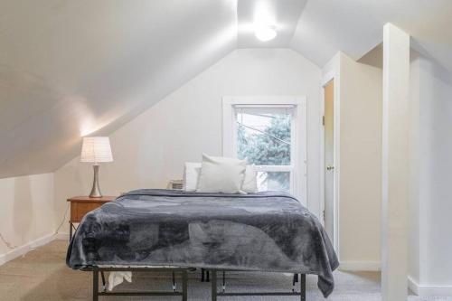 a white bedroom with a bed and a window at Large funky 2 or 3 bedroom unit in prime location in Seattle