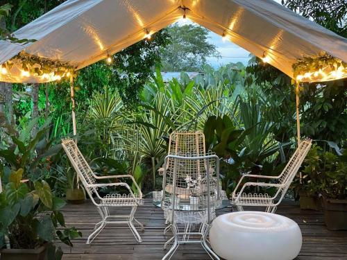 une terrasse avec des chaises et une table sous une tente dans l'établissement Hotel Madreselva, à Leticia