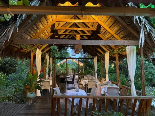 um restaurante com mesas e cadeiras em um deck de madeira em Hotel Madreselva em Leticia