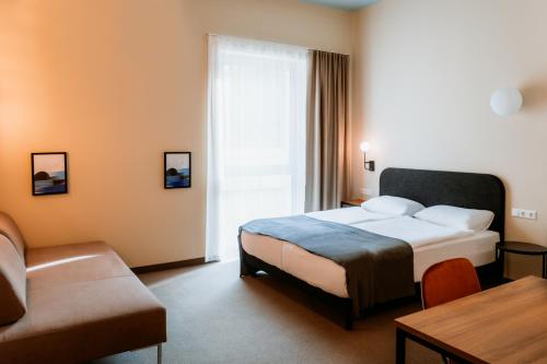 Habitación de hotel con cama y sofá en Moods Hotel Dortmund en Dortmund