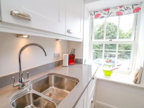 eine Küche mit einem Waschbecken und einem Fenster in der Unterkunft Bronte House in Carnforth