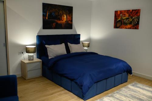 a bedroom with a blue bed and a night stand at Hotel Vila Discret in Satu Mare