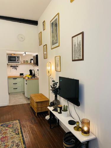 - un salon avec une table et une télévision dans l'établissement Appartement cosy en plein coeur historique, à Rouen