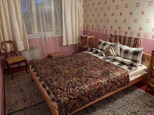 een slaapkamer met een bed en een stoel erin bij Cosy Appartment. Püssi town in Pyussi