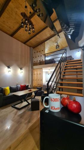 a living room with a couch and a staircase at Kheta Apartments Kazbegi in Stepantsminda