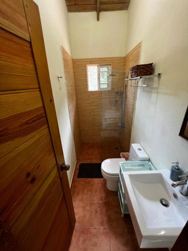 y baño con aseo y lavamanos. en Hacienda Claro de Luna 3 Bedrooms, en Jarabacoa