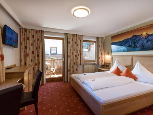 a hotel room with a bed and a desk at Apart Landhaus Heim in Mayrhofen