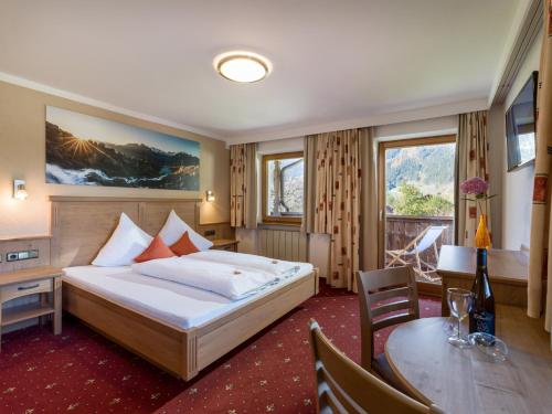 um quarto de hotel com uma cama e uma mesa em Apart Landhaus Heim em Mayrhofen