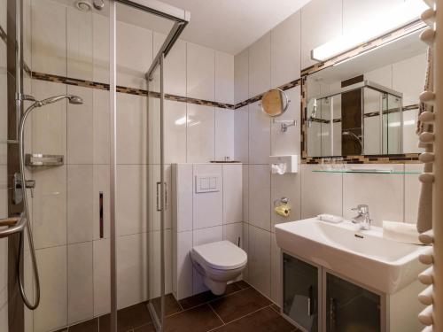a bathroom with a shower and a toilet and a sink at Apart Landhaus Heim in Mayrhofen