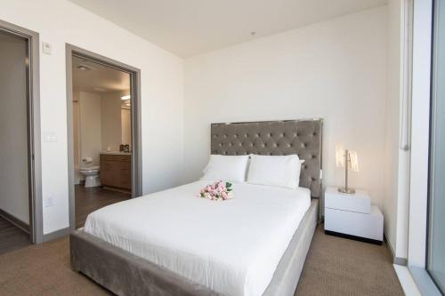 um quarto com uma grande cama branca com flores em Centrally Located Apartments with Free parking em Glendale