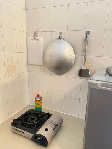 una cocina con fogones y una olla en la encimera en The Berlian Guesthouse - Two beedroom Apartment with Pool View en Port Dickson