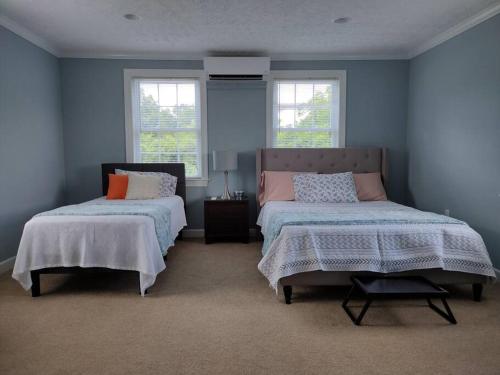 um quarto azul com duas camas e duas janelas em Backwoods Family Getaway! 3 Bedroom house! em Yanceyville
