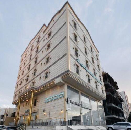 een groot wit gebouw in een stadsstraat bij فندق زهرة الربيع zahrat alrabie Hotel in Jeddah