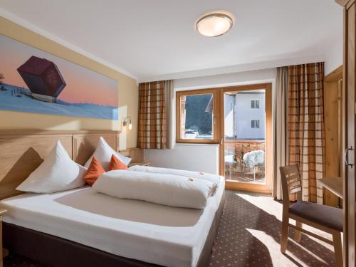 a bedroom with a large white bed and a window at Apart Landhaus Heim in Mayrhofen