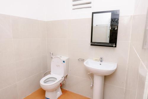 a bathroom with a toilet and a sink at Savenndra Hotel in Ranala