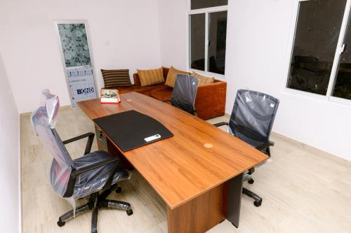 um escritório com uma mesa de madeira e duas cadeiras em Savenndra Hotel em Ranala