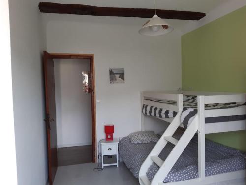 sypialnia z 2 łóżkami piętrowymi i drzwiami w obiekcie Logement calme et authentique à Espelette w mieście Espelette