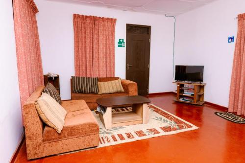 a living room with a couch and a table at Savenndra Hotel in Ranala