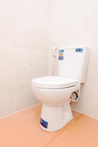 a bathroom with a white toilet in a room at Savenndra Hotel in Ranala