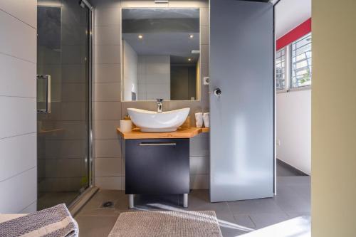 W łazience znajduje się umywalka i przeszklony prysznic. w obiekcie Gazi Urban Residence w Atenach