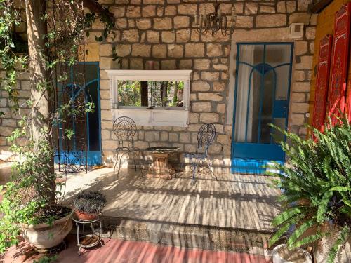 un patio con sillas y una ventana en un edificio en בית האבן העתיק מ-1885 en Rosh Pinna
