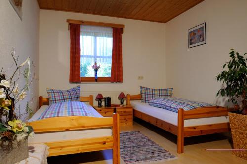 sypialnia z 2 łóżkami i oknem w obiekcie Ferienhaus Hütter w mieście Neuschönau