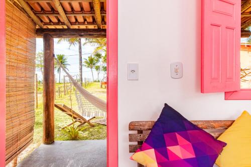 a room with a door to a porch with a hammock at Pousada Vila Rosa - Caraiva in Caraíva