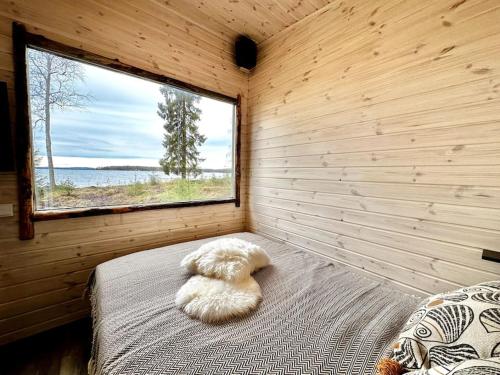 Cama en habitación de madera con ventana en Unique Cabin with Breathtaking Northern Light View, en Rovaniemi