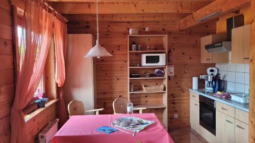 eine Küche mit einem Tisch und einem rosa Tischtuch in der Unterkunft Ferienhaus Bliev-Hee Nr 1 in Klink