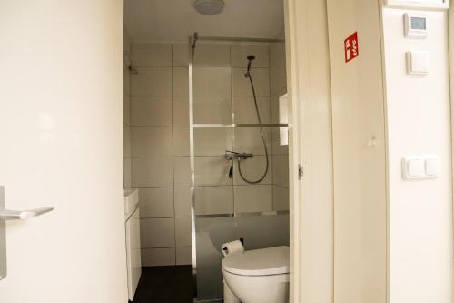 La petite salle de bains est pourvue d'une douche et de toilettes. dans l'établissement Emmen bed and breakfast, à Emmen