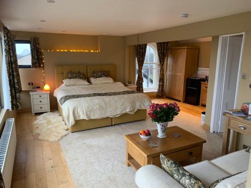 a bedroom with a large bed and a living room at The Penthouse Bowness Tranquil Loft Jacuzzi Bath & Complimentary Cascades Spa Membership in Bowness-on-Windermere