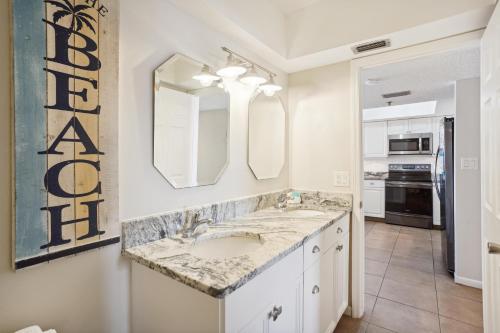 a bathroom with a sink and a large mirror at Las Brisas 202 in St Pete Beach