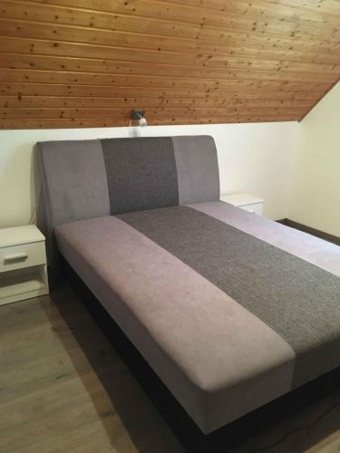 a bed in a bedroom with a wooden ceiling at Holiday home in Gyenesdias - Balaton 18816 in Gyenesdiás
