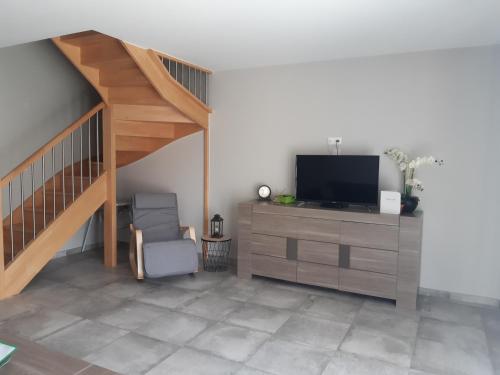 a living room with a tv and a staircase at GITE LA JOLIETTE ET LE CHESNAIE in Grillon