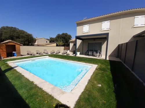 a swimming pool in a yard next to a house at GITE LA JOLIETTE ET LE CHESNAIE in Grillon