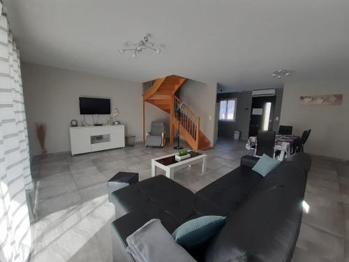 a living room with a couch and a dining room at GITE LA JOLIETTE ET LE CHESNAIE in Grillon
