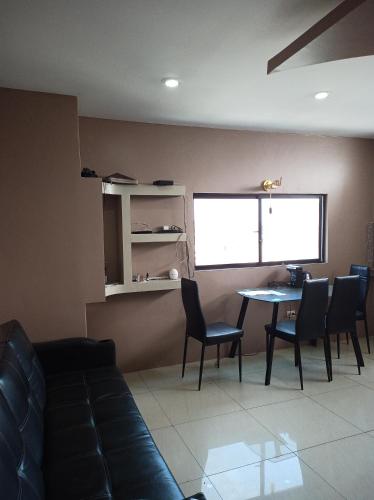 sala de estar con sofá, mesa y sillas en SUITE BOYACA, en Guayaquil