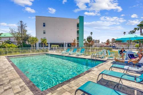 een zwembad met stoelen en een gebouw bij Madeira Del Mar 205 in St Pete Beach