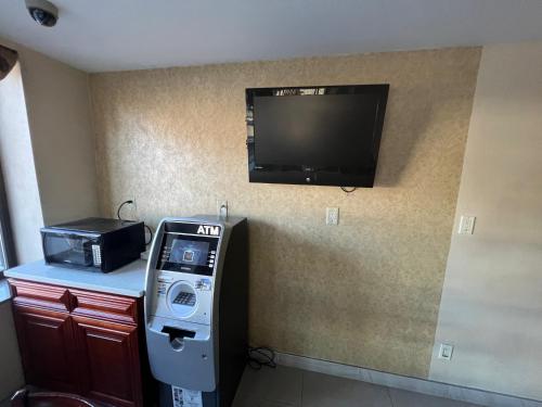 een kamer met een pinautomaat en een televisie aan een muur bij Atlantic Motor Inn in Brooklyn