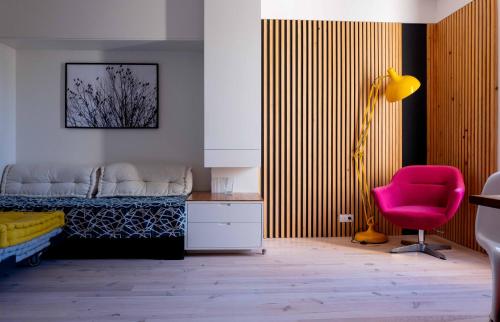 a bedroom with a bed and a pink chair at Modern appartment in the heart of Cap d'Antibes in Antibes